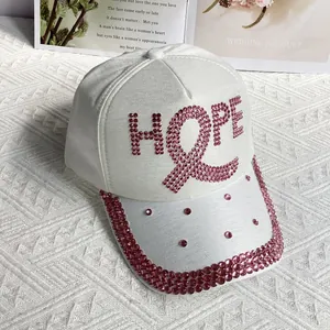 Close-up of white baseball cap with pink rhinestone HOPE letters and ribbon detail