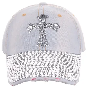 Detail of light blue denim baseball cap with rhinestone cross and frayed edge design