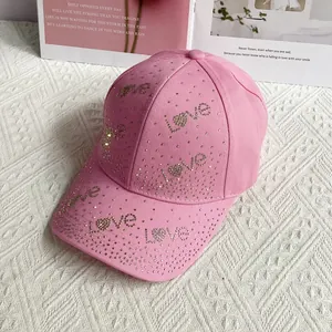 Détail d'une casquette rose ornée de strass brillants formant LOVE et motifs de cœur