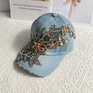 Detailansicht der Denim-Basecap mit goldener Blumenstickerei und eingebetteten Steinen