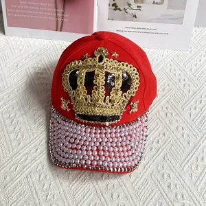 Detail of red crown baseball cap featuring pearls, rhinestones and metal star studs
