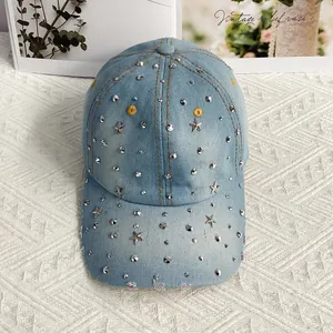 Dettaglio cappello denim azzurro con borchie a stella d'argento e visiera usurata
