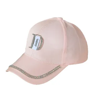 Detail of pink baseball cap featuring rhinestone letter D and decorative branded strap