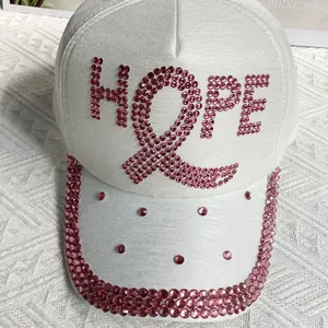 Close-up of pink rhinestones forming the HOPE letter and ribbon on a white baseball cap