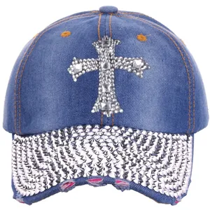 Detail of rhinestone cross patch and distressed brim on navy denim baseball cap
