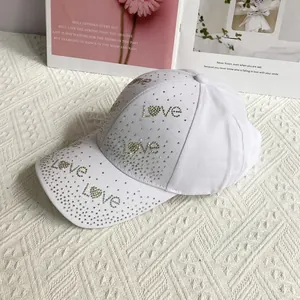 Détail des strass brillants formant LOVE sur une casquette en coton blanc