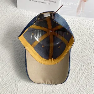 Internal view of denim baseball cap showing cotton stitching and leather strap adjustment