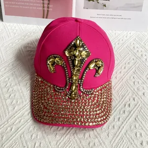 Close-up of rose pink denim hat with golden fleur-de-lis and rhinestone brim details