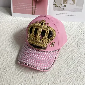 Detailed view of pink crown baseball cap with hand-sewn pearls and sparkling rhinestones