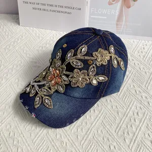 Detail einer blauen Denim-Baseballkappe mit goldener Stickerei und Strasssteinen