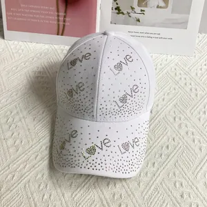 Détail de la casquette blanche avec lettres d'amour et motifs de cœur en strass brillants