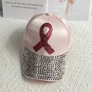 Detail of pink satin baseball cap featuring rhinestone ribbon and crystal brim