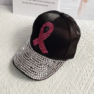 Detail of pink rhinestone ribbon and silver crystals on a black satin baseball cap