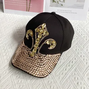 Macro detail of black denim baseball cap with fleur-de-lis yellow rhinestone pattern