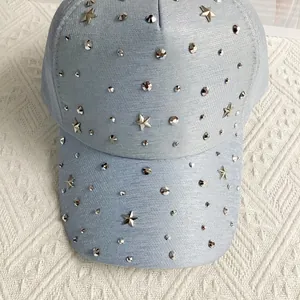 Detail einer hellblauen Baumwoll-Baseballkappe mit glitzernden silbernen Stern-Steinen