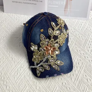 Detailansicht der handbesetzten Strasssteine und goldenen Stickerei auf der Denim-Kappe