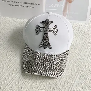 Close-up of white cotton baseball cap with rhinestone cross patch and shimmering brim