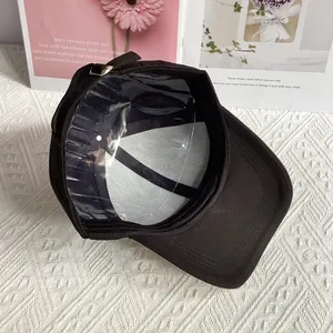 Detail view of denim baseball cap interior with stitching and adjustable metal buckle