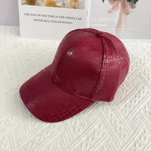 Detailed macro view of the crocodile embossed texture on a burgundy baseball cap fabric