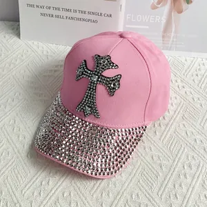Close-up of pink baseball cap featuring rhinestone cross and shimmering crystal brim