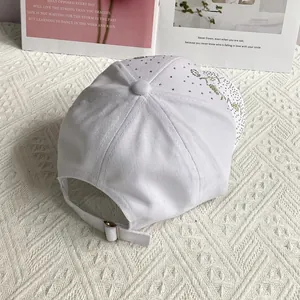 Détail de la boucle en métal argenté sur la casquette de baseball blanche à strass LOVE