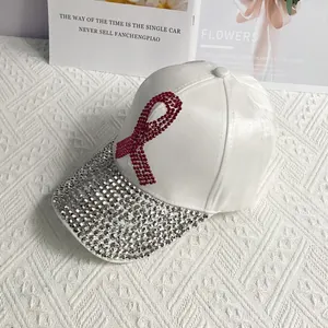 Detail of white satin baseball cap with pink rhinestone ribbon and sparkling diamond brim