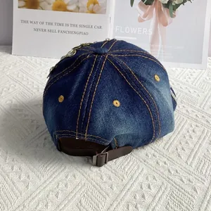 Detail der verstellbaren Metallschnalle und Strasssteine auf der blauen Denim-Kappe