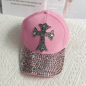 Close-up of pink baseball cap featuring a rhinestone cross design and sparkling brim