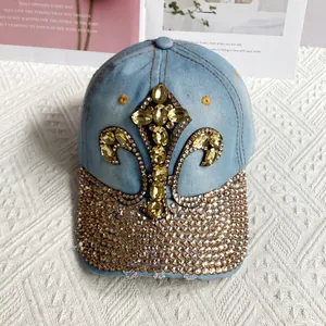 Close-up of denim baseball cap with crystal fleur-de-lis and rhinestone brim detail