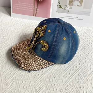 Detail of blue denim baseball cap with crystal scroll pattern and rhinestone brim