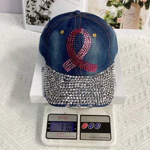 Detail of a denim baseball cap with pink rhinestone ribbon and silver crystals on the brim