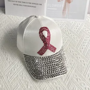 Detailed view of pink rhinestone ribbon and sparkling silver gems on a white satin cap
