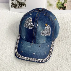 Détail d'une casquette en jean avec cœurs en strass et bordure ornée de rivets