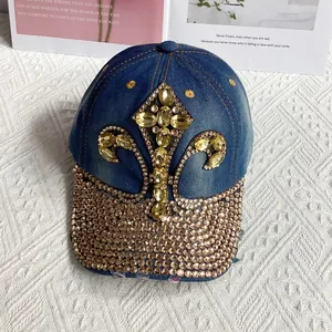 Close-up of golden rhinestones and iris flower embroidery on a denim baseball cap