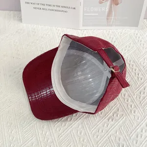 Detail of red crocodile texture PU leather baseball cap with adjustable gold buckle