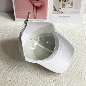 Detail of white baseball cap interior with stitching, support panel, and metal buckle