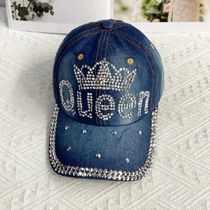 Détail de la casquette en jean bleu avec logo Queen en strass et couronne étincelante