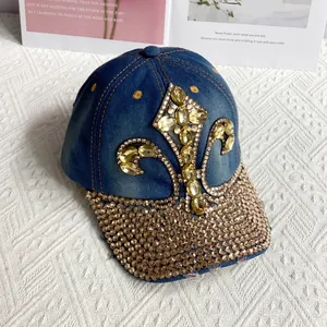 Macro view of blue denim baseball cap featuring amber fleur-de-lis rhinestones and gold studs