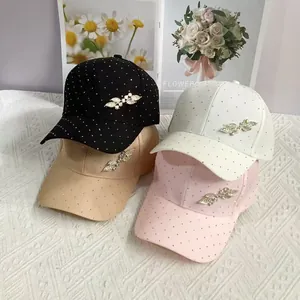 Detail of four baseball caps with rhinestones and leaf sequin embroidery on display