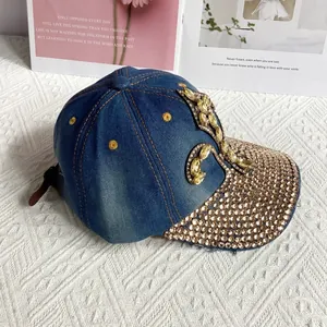 Close-up of blue denim baseball cap with gold rhinestones and floral gem details