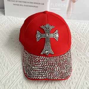 Detail of red baseball cap featuring silver rhinestone cross and sparkling studded brim