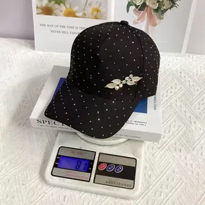 Close-up of black rhinestone baseball cap on scale showing 81g weight and leaf detail