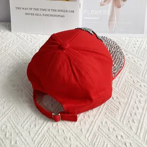 Detail of red denim baseball cap featuring sparkly rhinestones and metallic floral accents