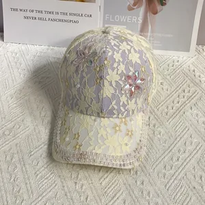 Détail de la casquette en dentelle lilas avec bordure en perles et fleurs en strass brillant