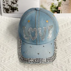 Détail des lettres LOVE en strass brillants et bordure de casquette en jean ornée de cristaux