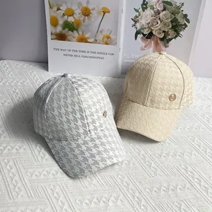 Houndstooth baseball cap with gold M logo in light grey and beige apricot color
