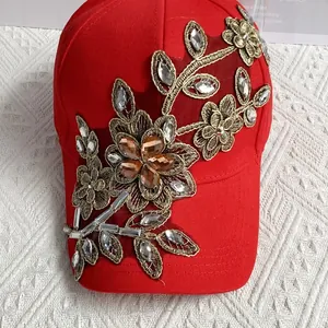 Detail der roten Baseballkappe mit Goldstickerei und Besatz aus glitzernden Strasssteinen