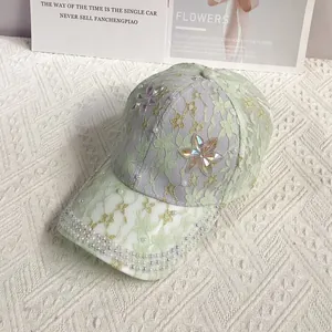 Détail d'une casquette en dentelle lavande avec perles et fleurs en strass étincelants