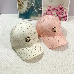 Dettagli di cappellini da baseball di lusso con strass e logo C dorato in bianco e rosa