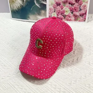 Dettaglio cappellino rosa con strass luccicanti e logo C in metallo dorato